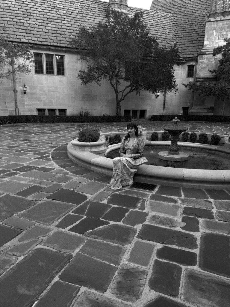 Woman sits by fountain in courtyard